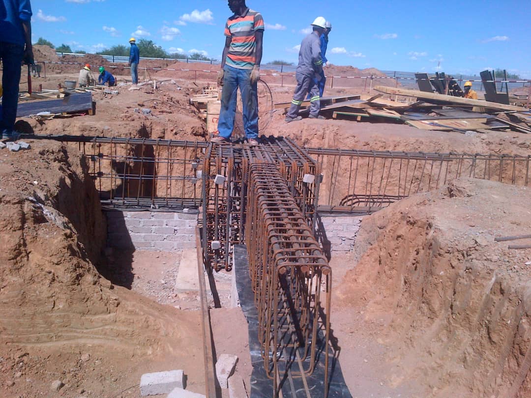 Construction workers preparing reinforced steel foundations on a Namibian building site